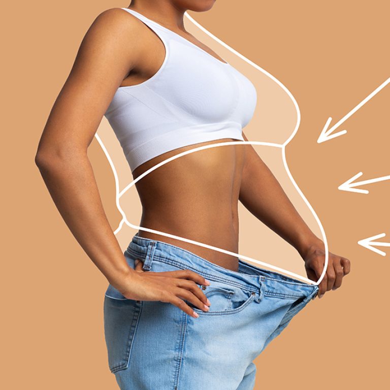Young slim african american female in big jeans enjoy weight loss result with fat abstract body around, arrows isolated on beige wall background, studio. Diet, health and body care, before and after