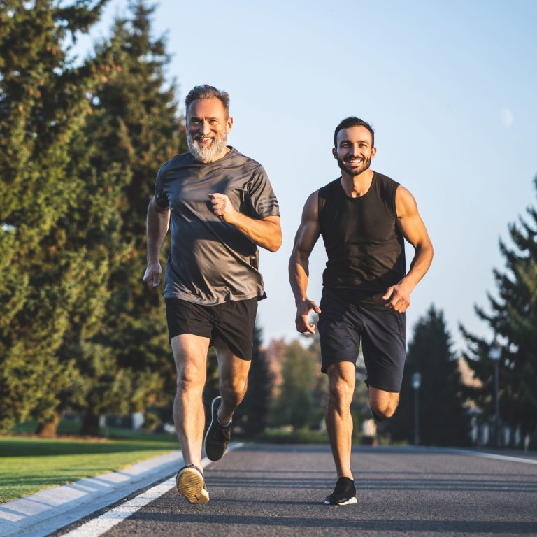 The happy father and a son running on a park road